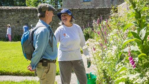 Volunteer speaking with visitors in the garden at Godolphin, Cornwall